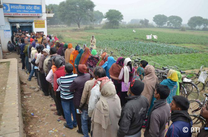 Mirzapur: Villagers line up in front of a SBI branch to withdraw cash in Mirzapur on Thursday. PTI Photo(PTI12_8_2016_000194B)